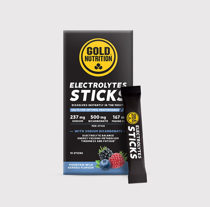 GoldNutrition electrolytes sticks showing colorful powder packets and a glass of water with dissolved electrolyte drink.