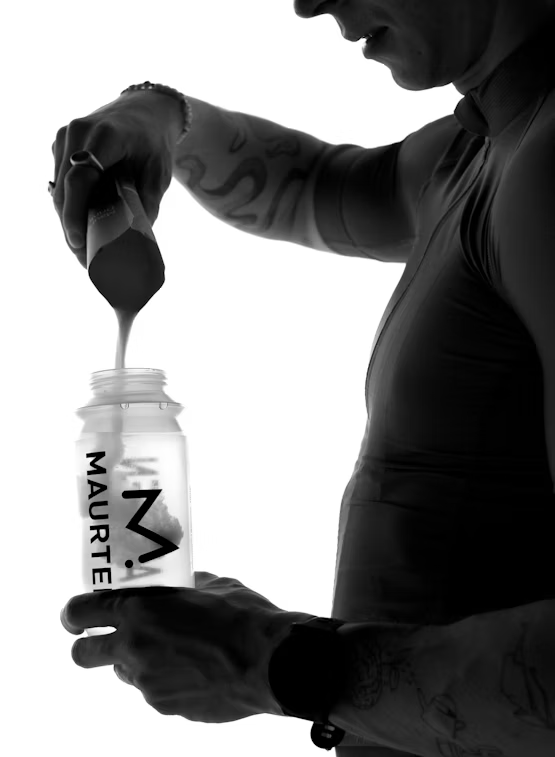 Single-serve Maurten Drink Mix 320 packet with orange flavor, featuring vibrant packaging and a scoop of powder.